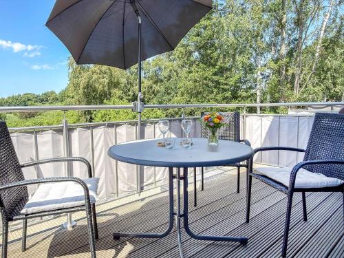 a blue table and chairs on a deck with an umbrella at Tordalk 09 in Prerow