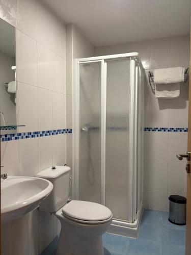 a bathroom with a shower and a toilet and a sink at Hostal El Poligono in Zamora