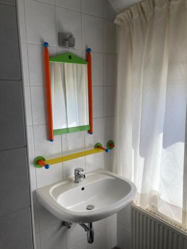 a bathroom with a sink and a mirror and a window at Magnolia in Wuustwezel