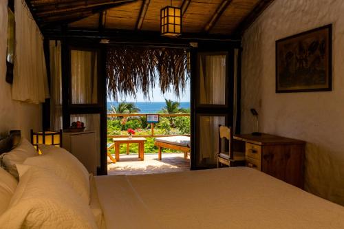 a bedroom with a bed and a view of the ocean at Las Cabañas de Antica in Vichayito