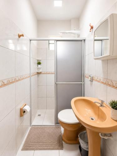 a bathroom with a shower and a toilet and a sink at Solar das Andorinhas Pousada in Itapoa