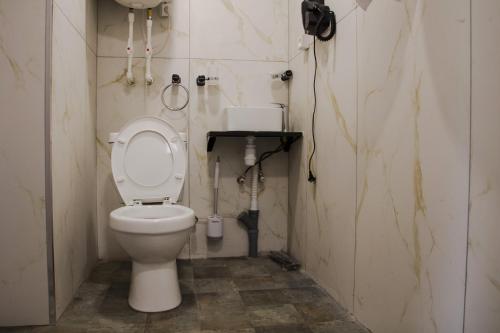 a bathroom with a toilet and a phone on the wall at Villatun in Stepʼanavan
