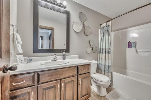 a bathroom with a sink and a toilet and a mirror at Bridges Bay Vacation Cabin 279 in Arnolds Park