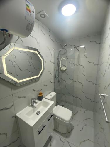 a bathroom with a toilet and a sink and a mirror at Pateriku Apartments in Shkodër