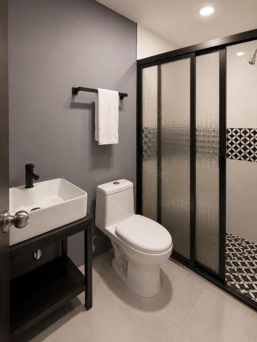 ein Badezimmer mit Toilette, Waschbecken und Dusche in der Unterkunft Adhoc Macro in Monterrey