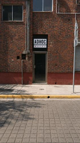 een bakstenen gebouw met een geïmproviseerd bord erop bij Adhoc Macro in Monterrey