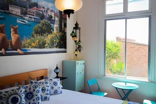 a bedroom with a bed and a large window at Casa Fran Valparaíso | Vive un Hotel Temático in Valparaíso