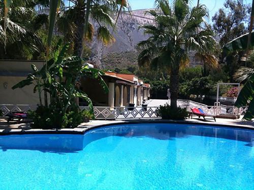 a large blue swimming pool in front of a house at Hotel Al Togo Fitness & Relax in Vulcano