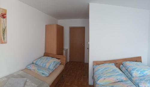 a small bedroom with two beds and a closet at Cyklami in Pobierowo