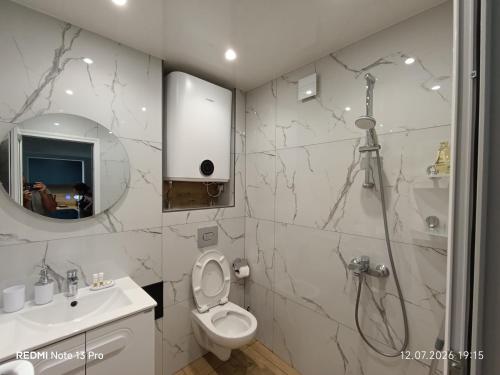 a bathroom with a shower and a toilet and a sink at SEA VIEW FLORA in Burgas