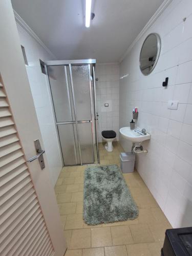 a bathroom with a shower and a toilet and a sink at Quarto próximo ao Lago do Major in Atibaia