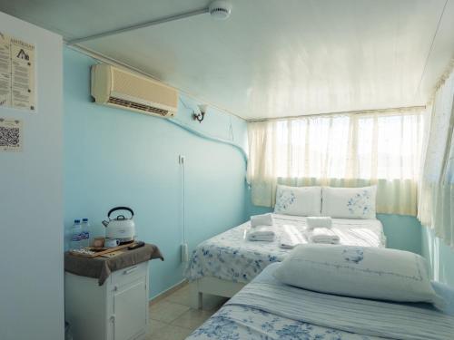 a blue bedroom with a bed and a window at Tarihi Rum Konağı Antikhan in Ayvalık