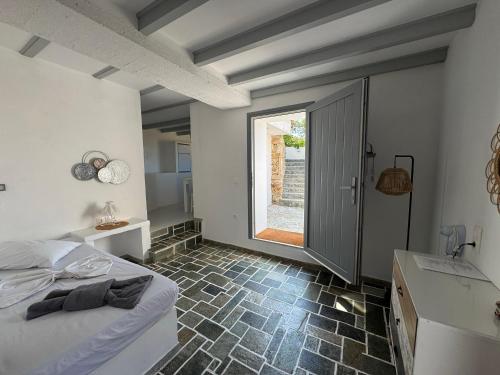 a bedroom with a bed and a bathroom with a window at Ergina Studios in Ios Chora
