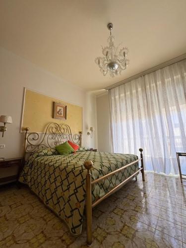 a bedroom with a bed with a chandelier and a window at Holy family in Pachino