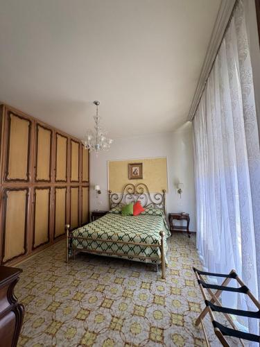 a bedroom with a bed and a chandelier at Holy family in Pachino