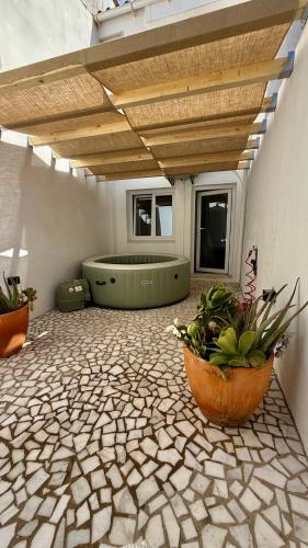 a patio with a hot tub and potted plants at Habita SerpaPinto in Estremoz