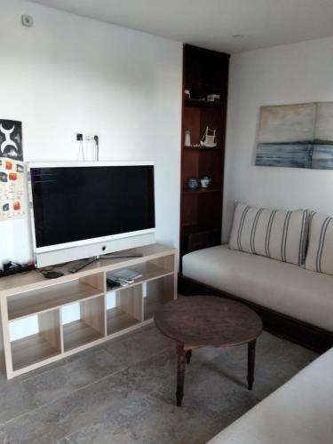 a living room with a couch and a flat screen tv at Maison de plage Marsa M'diq 2 chambres et Salon in M'diq