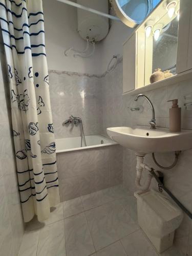a white bathroom with a sink and a bath tub at Male home in Maletiánoi