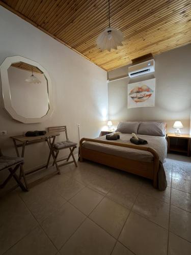 a bedroom with a bed and a table and a mirror at Male home in Maletiánoi
