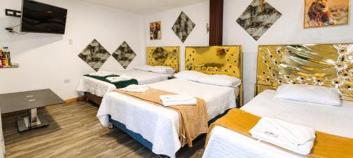 a room with three beds and a flat screen tv at Concubinas del Inca in Cajamarca