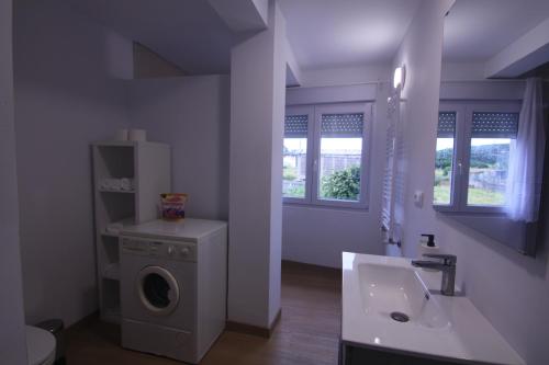 a bathroom with a washing machine and a sink at Fogar dos Americanos in Borneiro