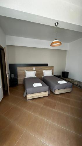 two beds in a large room with at Syrtaki Studios in Kámpos