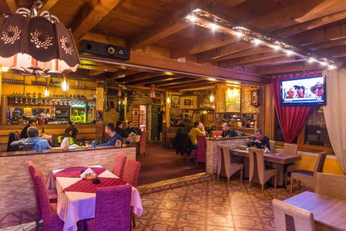 a restaurant with people sitting at tables and a bar at Motel Orhideja in Donji Vakuf