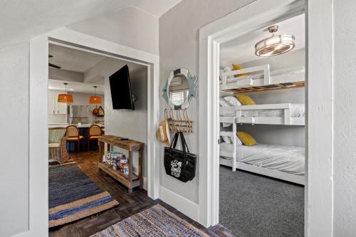 a room with a hallway with bunk beds and a living room at Coastal Escape, Steps to Beach, Fire Pit in Galveston
