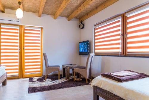 a bedroom with a bed and a table and chairs at Motel Orhideja in Donji Vakuf