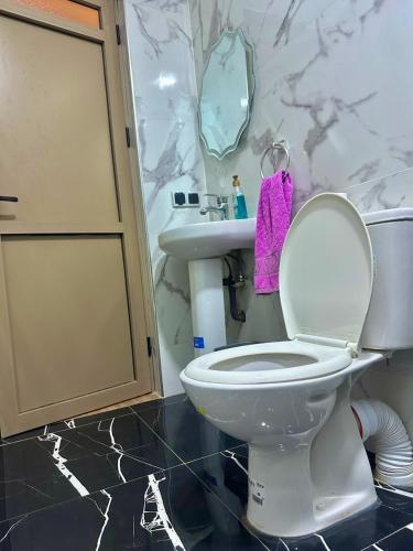 a bathroom with a white toilet and a sink at House Aisha Rooftop Hostel in Aourir