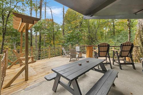 a wooden deck with a picnic table and chairs at Breathtaking Boutique Treehouse nestled in clouds in Beech Mountain