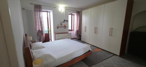 a bedroom with a white bed and white cabinets at Deby House in Oggebbio