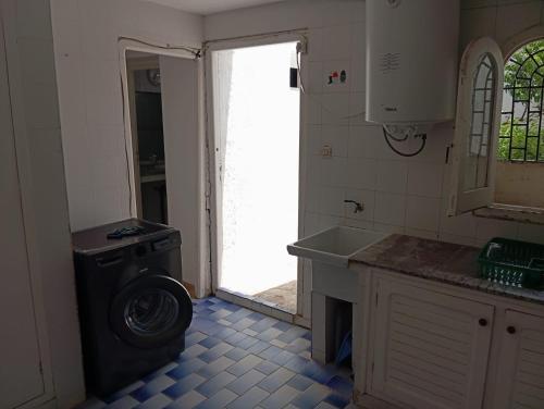 a kitchen with a washing machine and a sink at Maison de plage familiale à Cabo in Cabo Negro