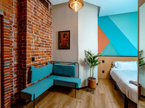 a bedroom with a blue bench and a bed at Hotel Terracota mx in Mexico City