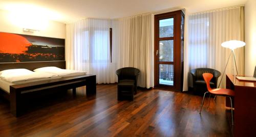 a bedroom with a bed and a table and chairs at arte Hotel Linz in Linz