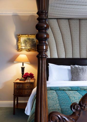 a bedroom with a bed and a table with a lamp at Earls Court House in Killarney