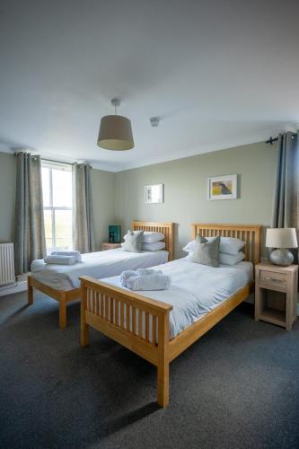 a bedroom with two beds and a large window at The Sportsman in Amberley