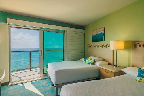 a hotel room with two beds and a balcony at Waikiki Circle Hotel by Castle in Honolulu