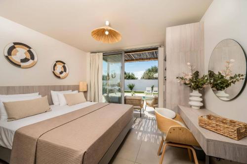 a bedroom with a large bed and a table and chairs at Villa Romas 2 by Villa Plus in Vasilikos