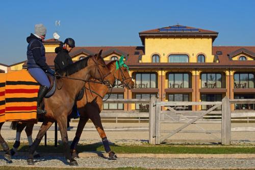 two people riding on horses in front of a building at Agriturismo Il Boschetto in Ornago