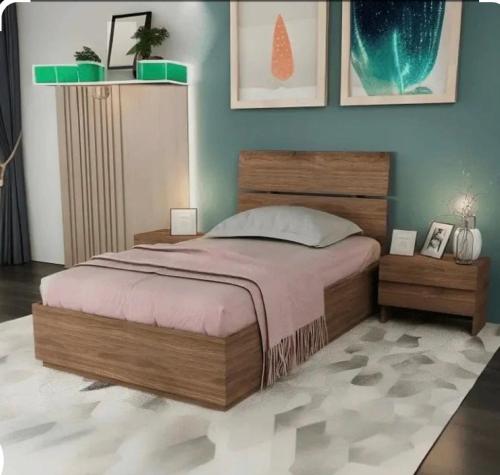 a bedroom with a large bed and a blue wall at شقق ورد in Al Barkah