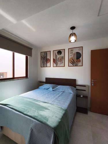 a bedroom with a bed with a blue comforter at Duplex Praia de Imbassaí in Mata de Sao Joao