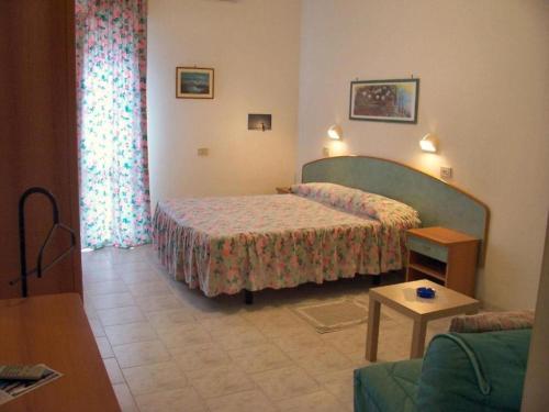 a bedroom with two beds and a couch and a table at Hotel Vecchia Rimini - DAY USE dalle 10 alle 20 in Lido degli Estensi
