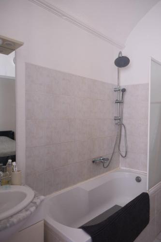 a bathroom with a bath tub and a sink at Les Vans Centre-village in Les Vans