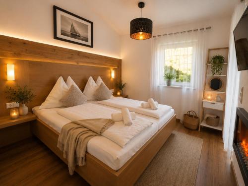 a bedroom with a large bed with white sheets at Ena Appartements in Altenmarkt im Pongau