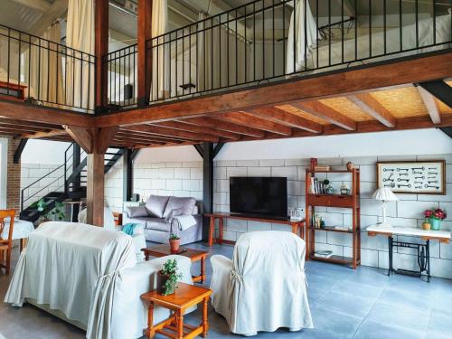 a living room with white chairs and a loft at El Pajar - Apartamento rural en la Vía Verde in Luque