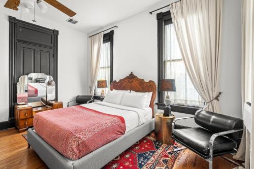 a bedroom with a bed and a chair and a mirror at Saint Helens House-Hotel Historic District Near Cruise Port in Galveston