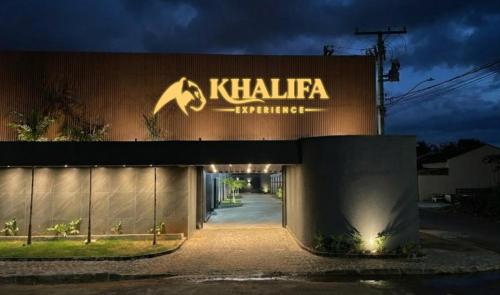 a building with a sign on the side of it at Khalifa Experience Motel in Itumbiara