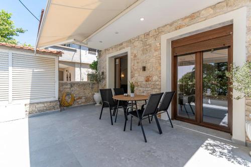 a patio with a table and chairs on it at Afytos Rooms in Afitos