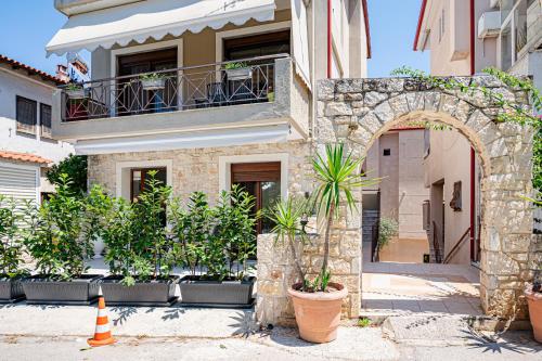 a building with an arch and potted plants in front of it at Afytos Rooms in Afitos